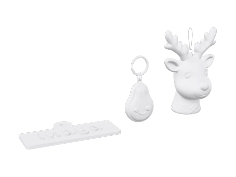 A name keychain, an avocado keychain and a reindeer ornament on one plate